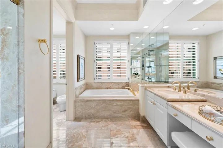 Bathroom featuring vanity, a bidet, a bath, recessed lighting, and light marble finish floors