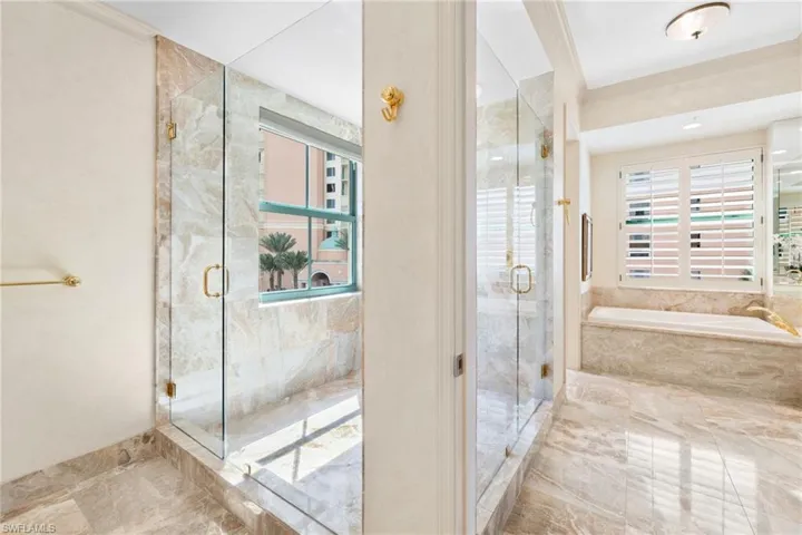 Full bathroom featuring a bath, a marble finish shower, plenty of natural light, and ornamental molding