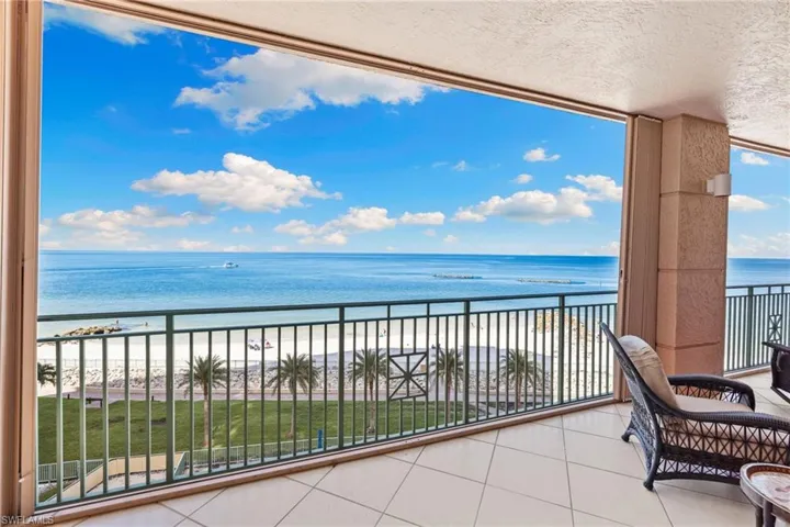 Balcony featuring view of water and beach