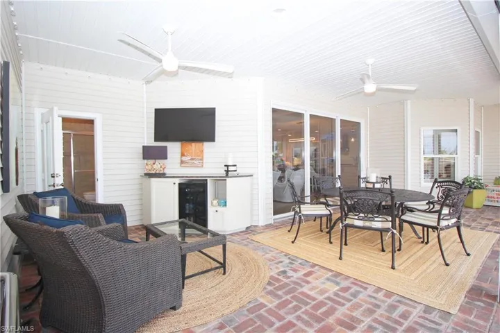Outdoor entertainment area featuring a TV, bar, and wine cooler.
