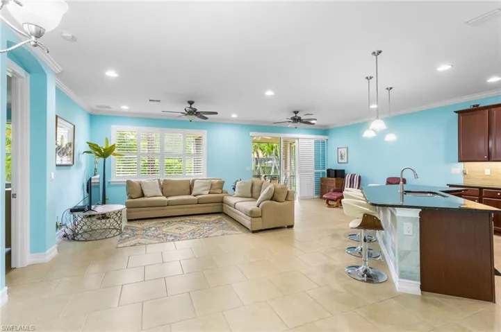 Living room featuring crown molding, recessed lighting, ceiling fan, and light tile patterned floors