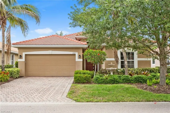 View of front facade featuring stucco siding, decorative driveway, a tile roof, and an attached garage