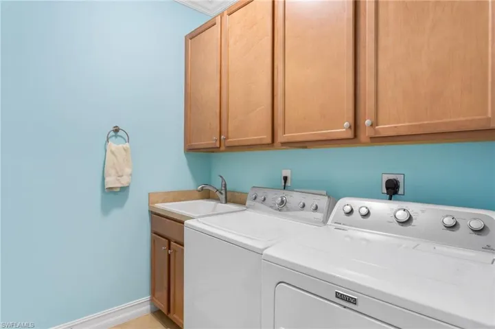 Washroom featuring cabinet space and washer and clothes dryer