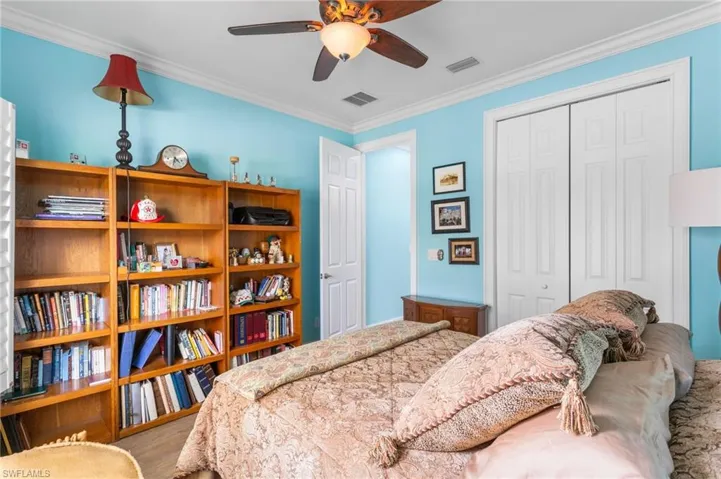 Bedroom with ornamental molding, ceiling fan, a closet, and wood finished floors