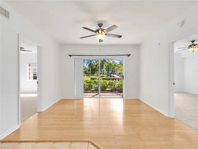 Living Room & Dining Area with Ceiling Fan and Sliders Leading to Screened In Lanai