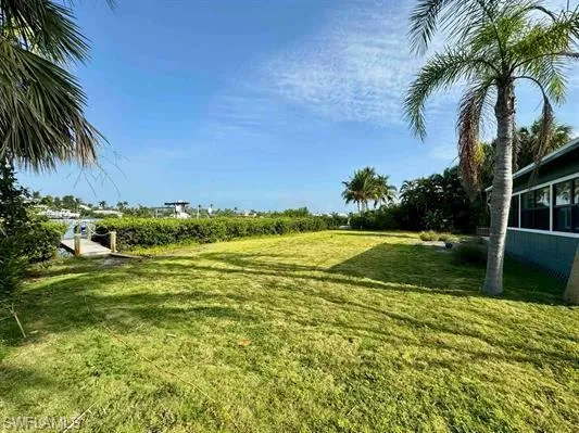 View of green lawn featuring a sunroom