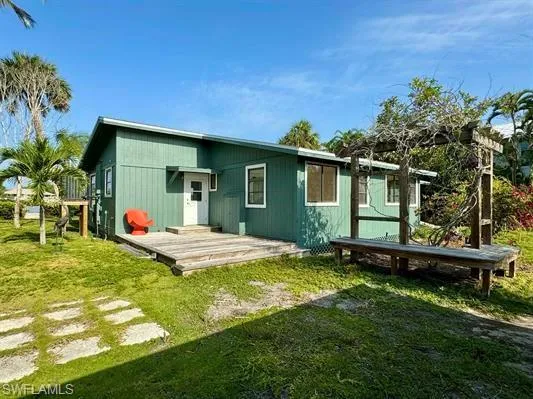 Rear view of house featuring a yard and a deck
