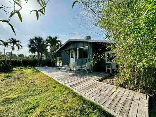 Back of house featuring a lawn and a wooden deck