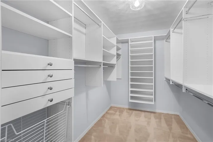 Custom closet system featuring shelving, drawers, and hanging rods