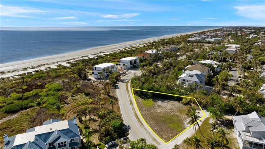 Aerial view of residential area featuring property boundaries highlighted and expansive coastline
