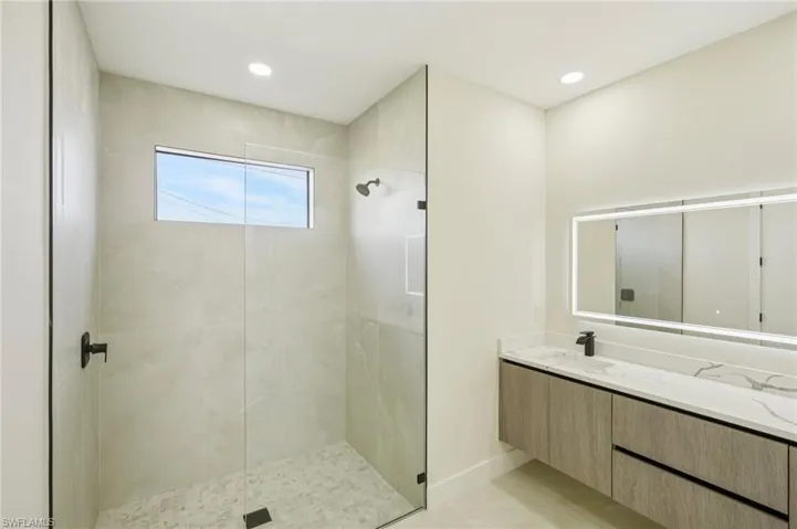 Full bathroom featuring vanity, walk in shower, recessed lighting, and light tile patterned floors