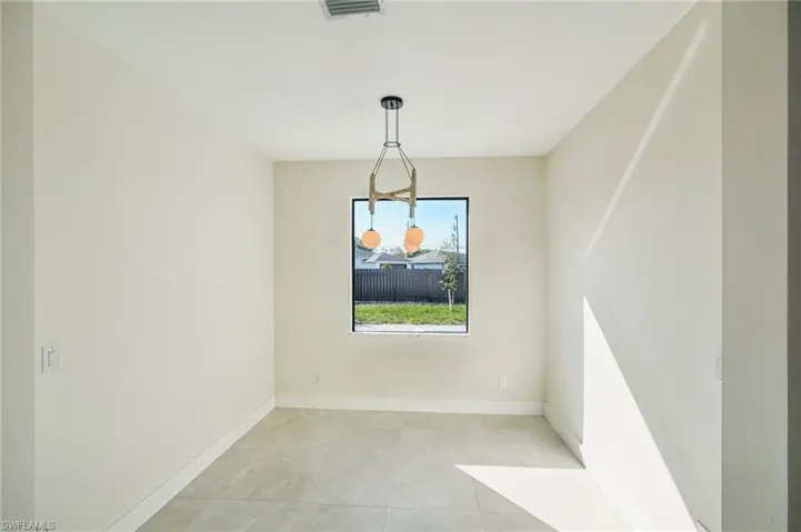 Unfurnished dining area with baseboards and light tile patterned floors