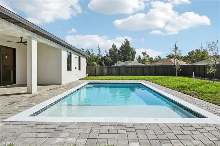 View of swimming pool with a ceiling fan, a patio area, and a fenced backyard
