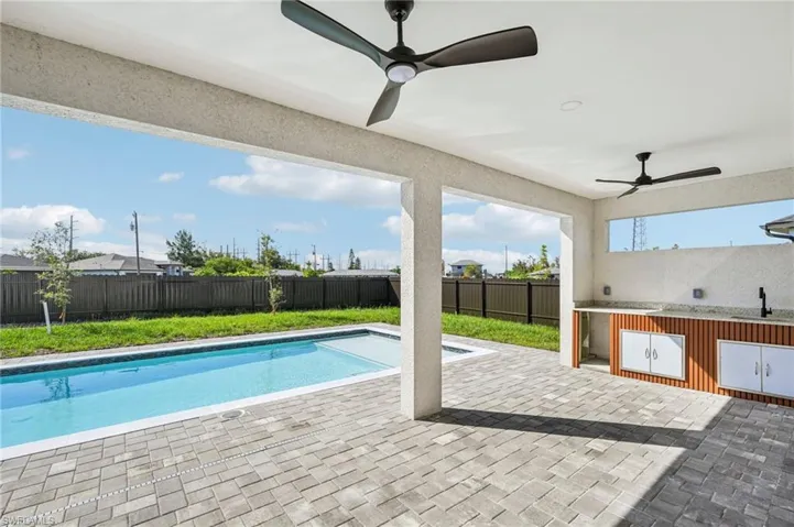 View of swimming pool featuring a fenced backyard, a patio area, and a ceiling fan