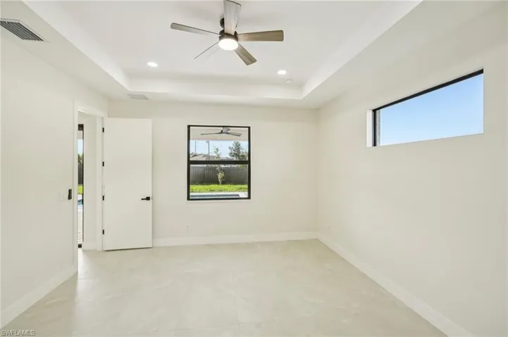 Spare room with a tray ceiling, ceiling fan, and recessed lighting