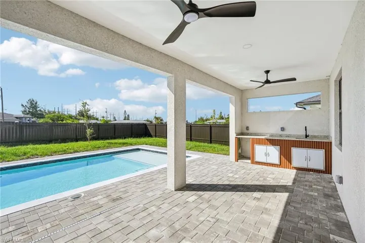 View of swimming pool featuring a fenced backyard, a patio area, and a ceiling fan