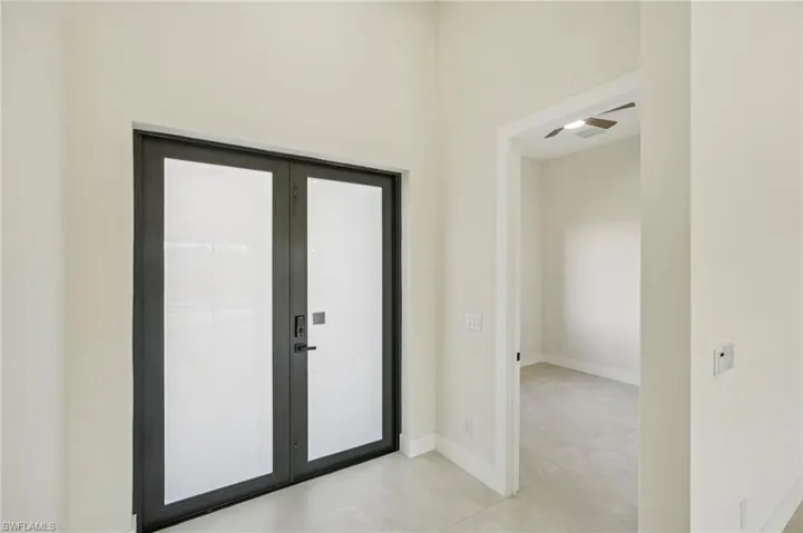 Doorway with baseboards and french doors