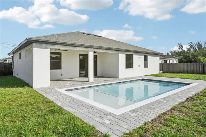 Back of house featuring a fenced backyard, a patio, a shingled roof, and a ceiling fan