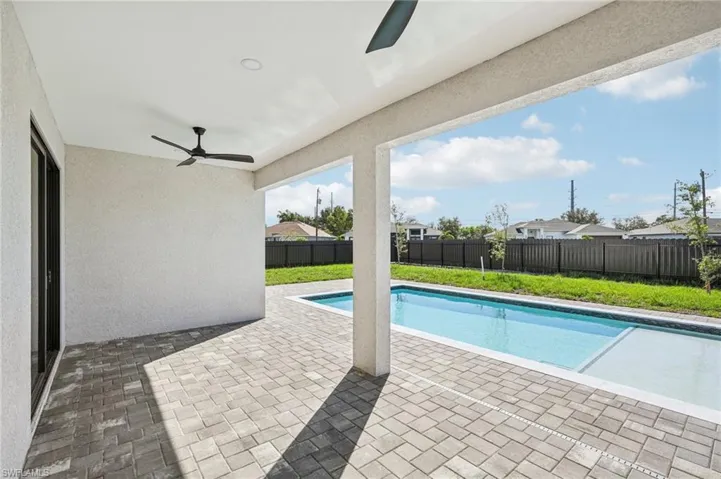 View of swimming pool featuring a patio, a fenced backyard, and a ceiling fan