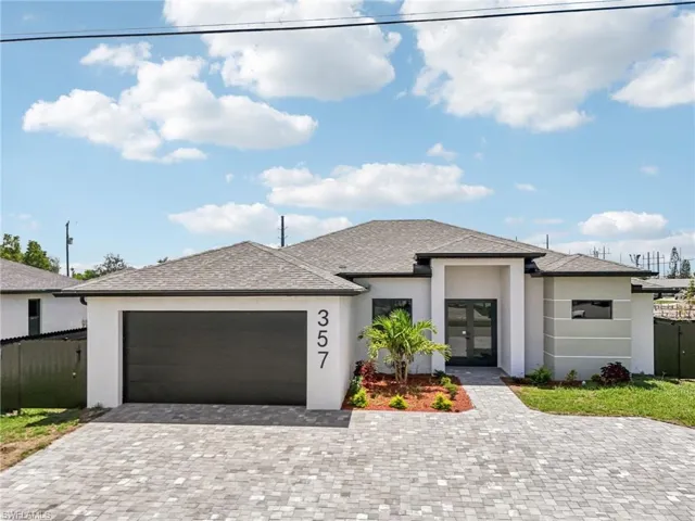 Prairie-style house featuring stucco siding, a garage, decorative driveway, and french doors