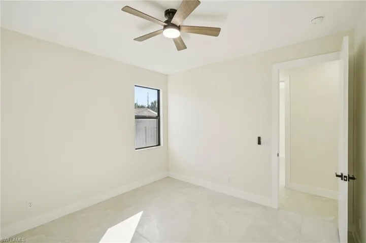 Spare room featuring baseboards and ceiling fan