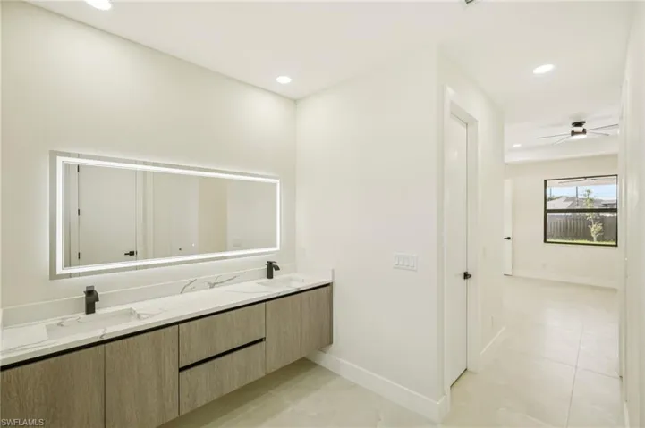 Full bathroom featuring double vanity, recessed lighting, light tile patterned floors, and ceiling fan