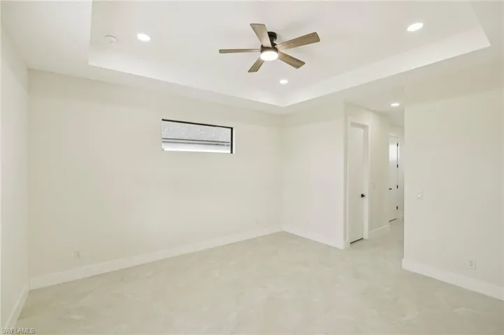 Empty room featuring a tray ceiling, recessed lighting, and ceiling fan