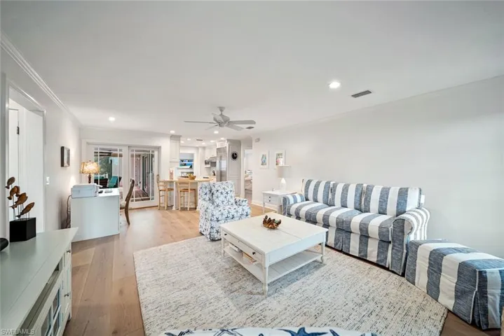 Living room featuring ceiling fan, light hardwood / wood-style flooring, and crown molding