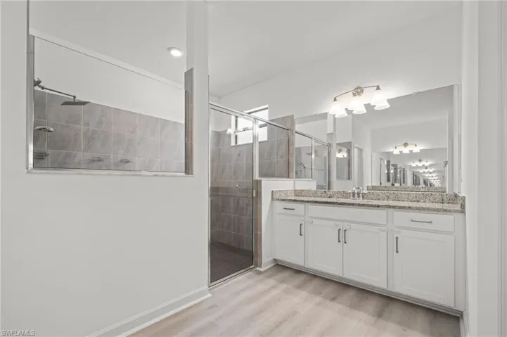 Full bathroom featuring vanity, a stall shower, and wood finished floors