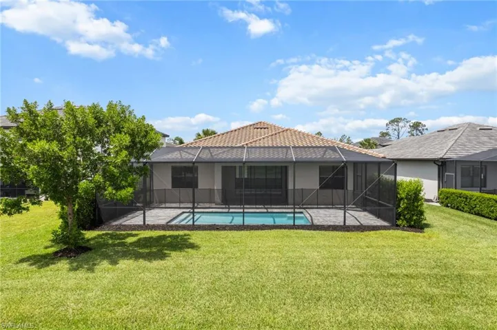 Rear view of house with a lawn, stucco siding, an outdoor pool, and a patio area