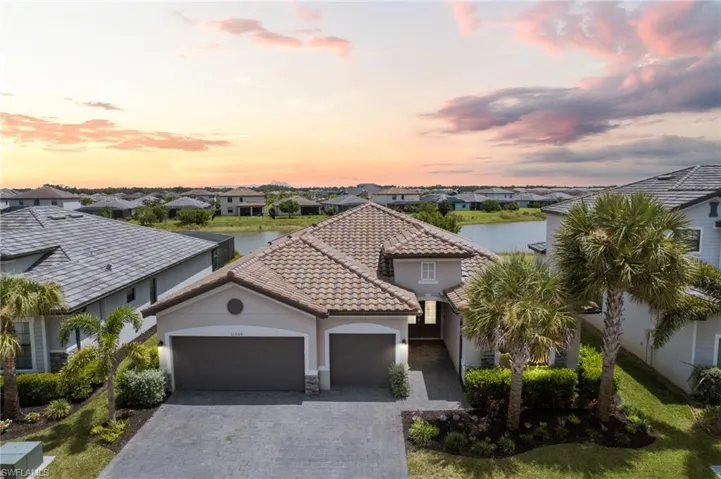 Mediterranean / spanish-style home featuring a garage, stucco siding, a water view, and decorative driveway