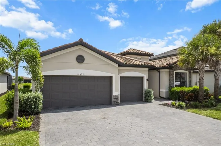 Mediterranean / spanish-style home featuring a garage, stone siding, and stucco siding