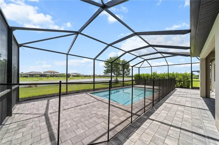 Outdoor pool with a patio area and glass enclosure