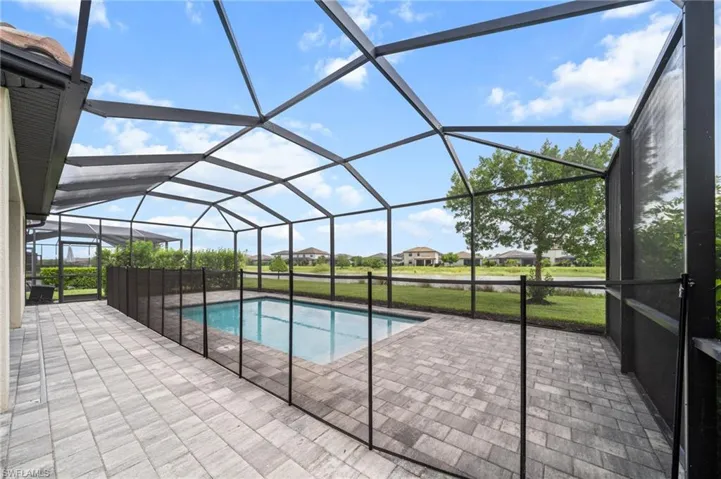 Outdoor pool with a patio and glass enclosure