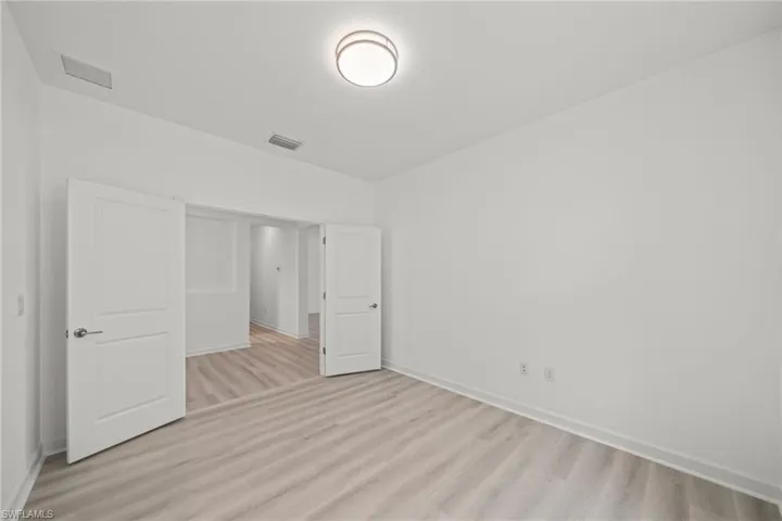 Unfurnished bedroom featuring light wood-type flooring and baseboards