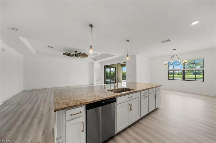 Kitchen featuring open floor plan, light wood-style flooring, dishwasher, and healthy amount of natural light