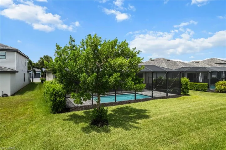 Swimming pool with a yard, a residential view, and a lanai