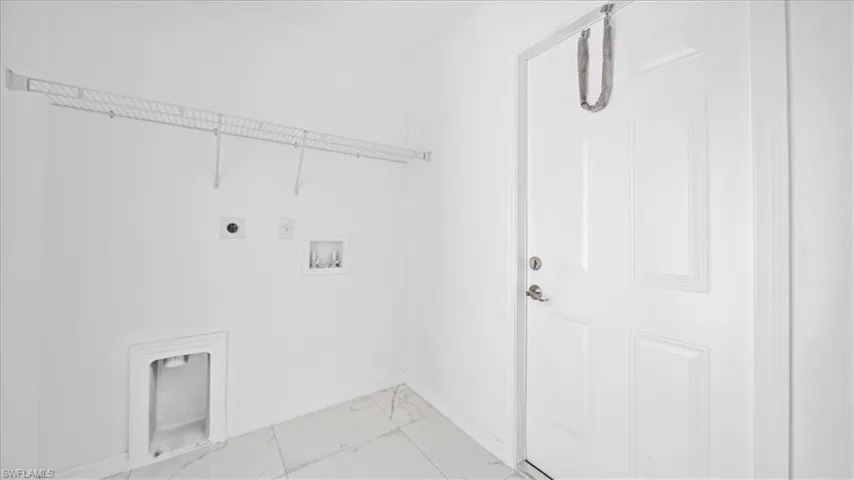 Laundry area featuring light marble finish floors, washer hookup, and electric dryer hookup