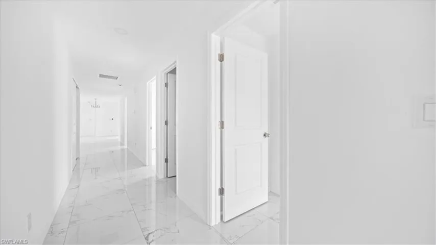 Hall with light marble finish floors and baseboards