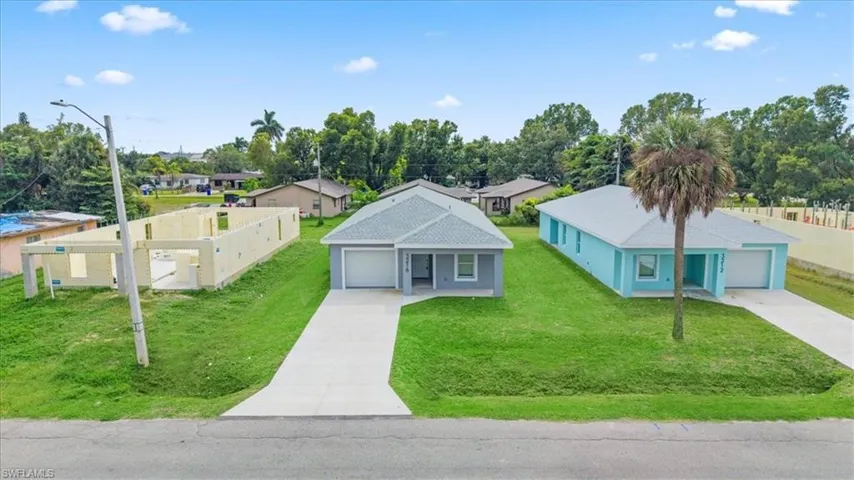 Ranch-style house featuring concrete driveway, a garage, a residential view, and a front yard