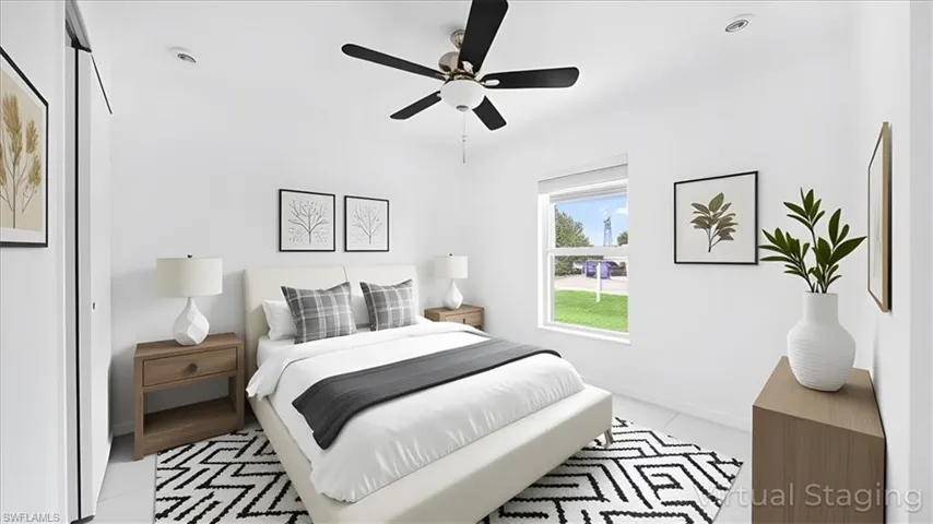 Tiled bedroom with a ceiling fan and baseboards