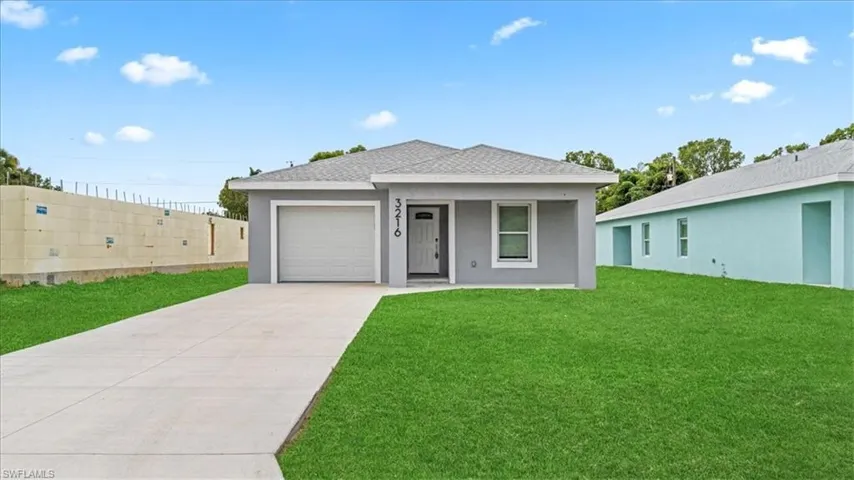 Ranch-style home with a front lawn, concrete driveway, stucco siding, a garage, and a shingled roof
