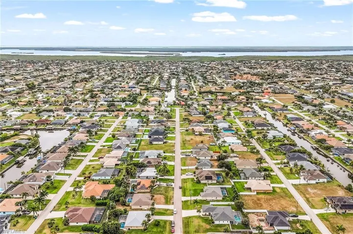 Aerial overview of property's location featuring a large body of water and nearby suburban area