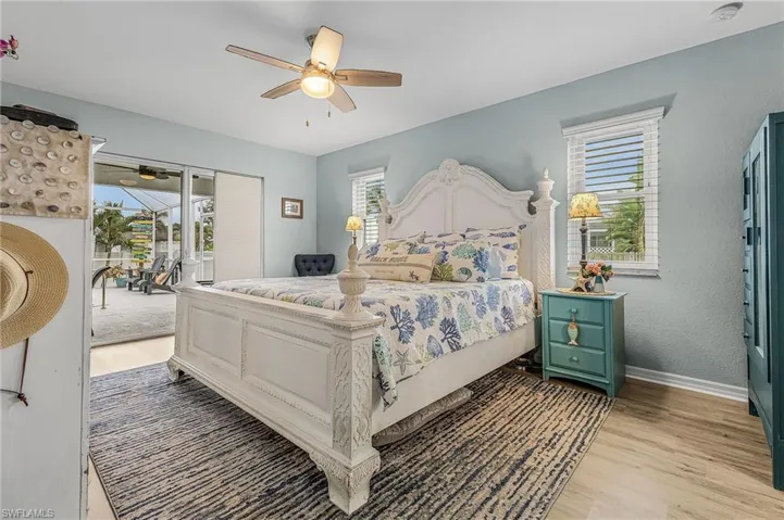 Primary Bedroom featuring access to outside, light wood-style flooring, and multiple windows