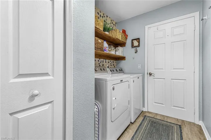 Washroom featuring light wood-style floors and washer and clothes dryer