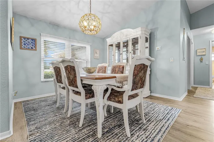 Dining room with a chandelier, lofted ceiling, and light wood-type flooring