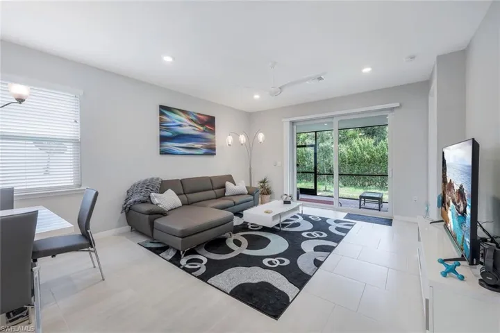 Living room with ceiling fan and light tile floors