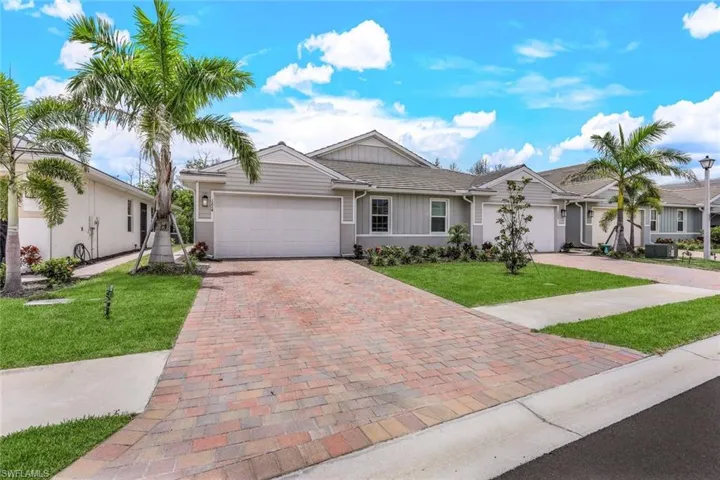 Ranch-style home with a garage, a front lawn, and central AC unit