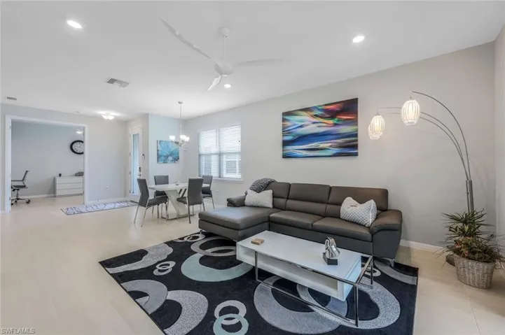 Living room with ceiling fan with notable chandelier