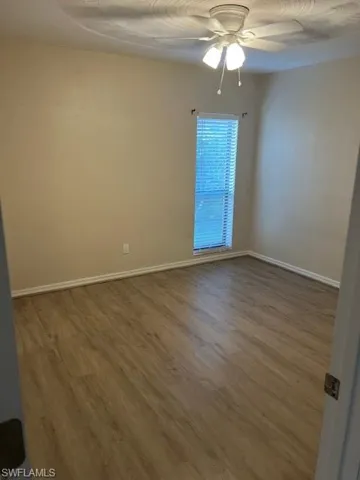 Empty room with ceiling fan and hardwood / wood-style floors